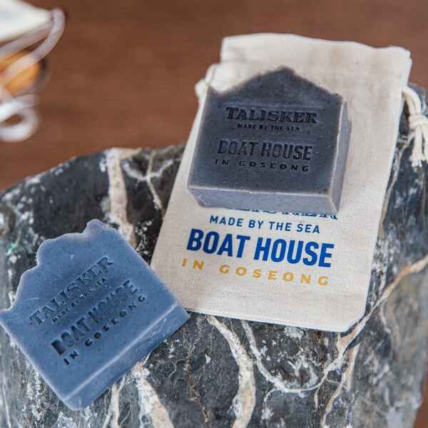 Two soap bars and a small pouch imprinted with 'Talisker Made by the Sea: Boathouse in Goseong'.